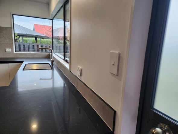 Modern black-bench kitchen interior with window view