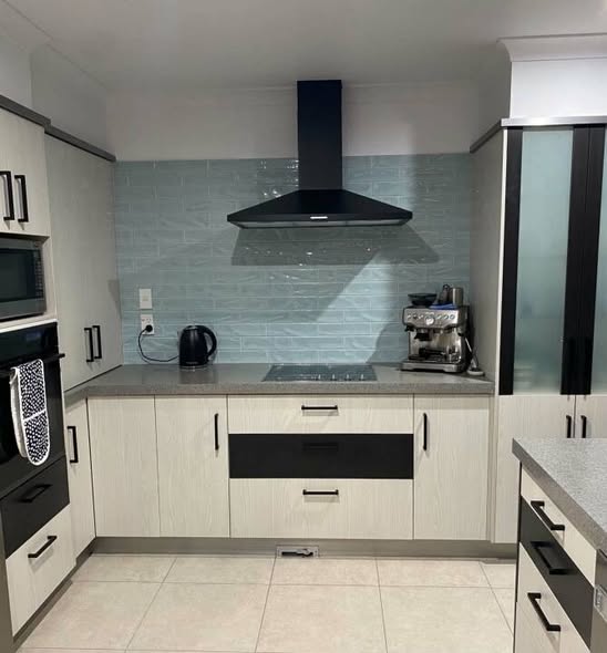 Soft grey-blue subway splashback with black rangehood