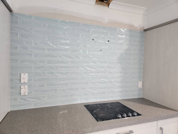 Grey-blue brick splashback behind stovetop