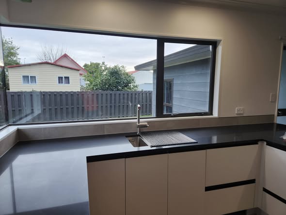 Slate grey large-format wider kitchen view with black benchtop