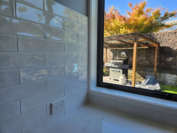 White glossy subway by window with outdoor BBQ view