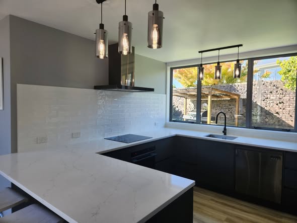 White glossy subway kitchen splashback with pendant lights and marble bench